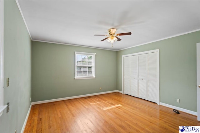 unfurnished bedroom featuring baseboards, ornamental molding, and a closet