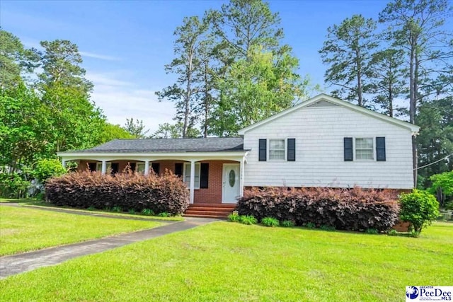 split level home with a porch, a front lawn, and brick siding