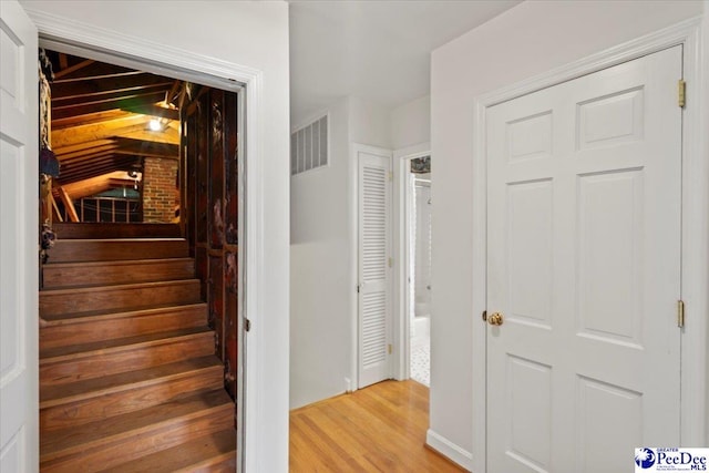 staircase featuring visible vents and wood finished floors