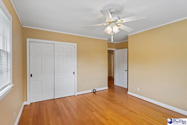 unfurnished bedroom with light wood-style floors, baseboards, ornamental molding, and a closet