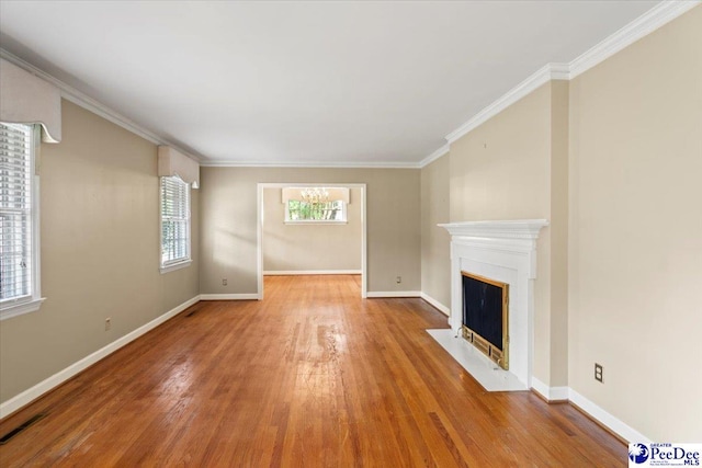 unfurnished living room with baseboards, a fireplace with flush hearth, crown molding, and wood finished floors