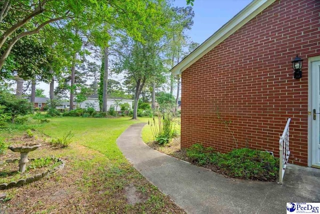 view of home's exterior featuring brick siding and a yard