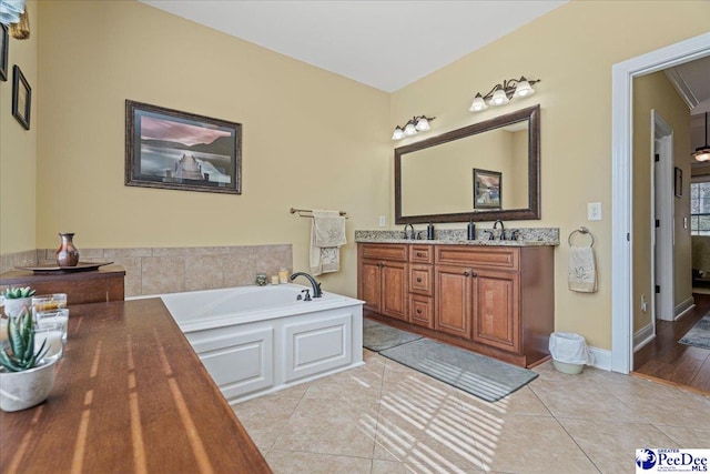 bathroom featuring vanity, a washtub, and tile patterned floors