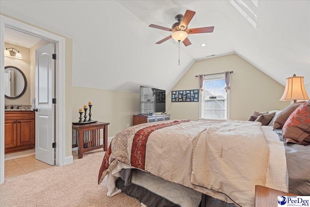 bedroom with ceiling fan, lofted ceiling, light carpet, and ensuite bath