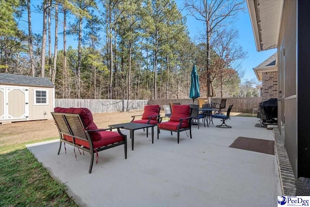 view of patio with area for grilling and a storage unit