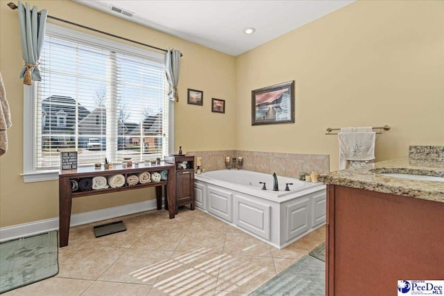 bathroom with vanity, a wealth of natural light, tile patterned flooring, and a bathtub