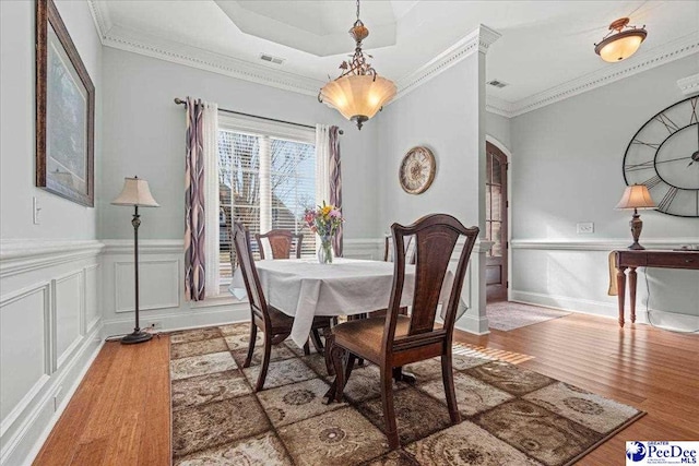 dining space featuring wood-type flooring and ornamental molding