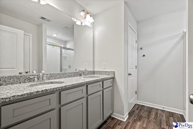 bathroom with vanity, hardwood / wood-style floors, and a shower with shower door