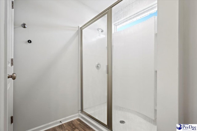 bathroom featuring wood-type flooring and a shower with shower door