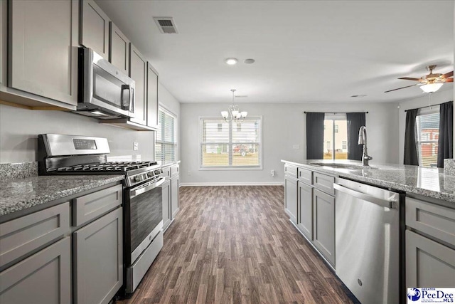 kitchen featuring stone counters, appliances with stainless steel finishes, sink, gray cabinetry, and dark hardwood / wood-style flooring