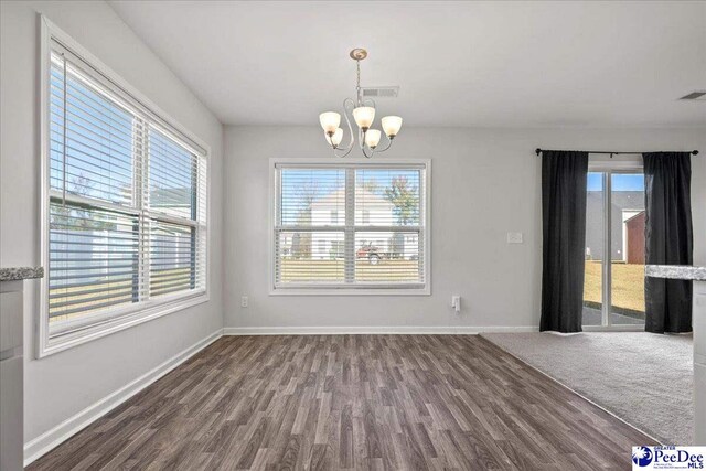 unfurnished dining area featuring dark hardwood / wood-style flooring and a chandelier