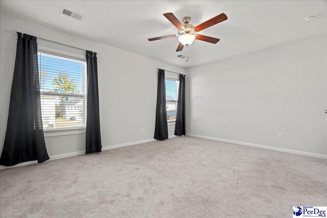 carpeted spare room featuring ceiling fan