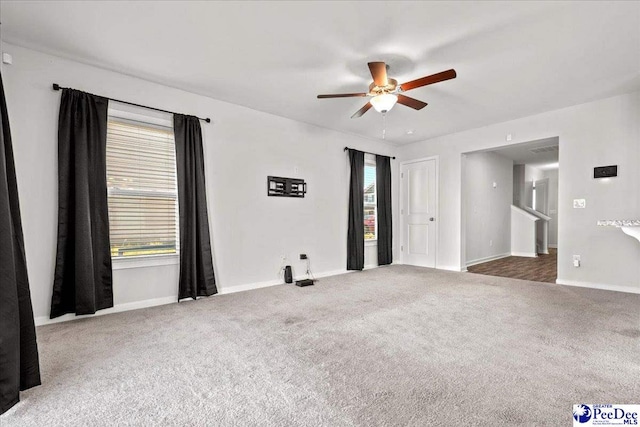 carpeted empty room featuring ceiling fan and a wealth of natural light