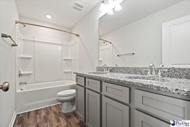 full bathroom with vanity, hardwood / wood-style flooring, bathtub / shower combination, and toilet