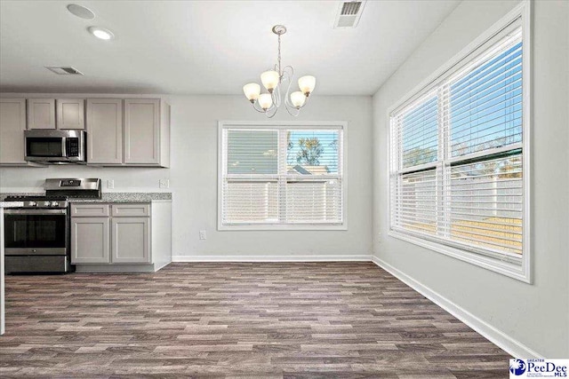 kitchen featuring gray cabinets, a chandelier, dark hardwood / wood-style flooring, hanging light fixtures, and stainless steel appliances