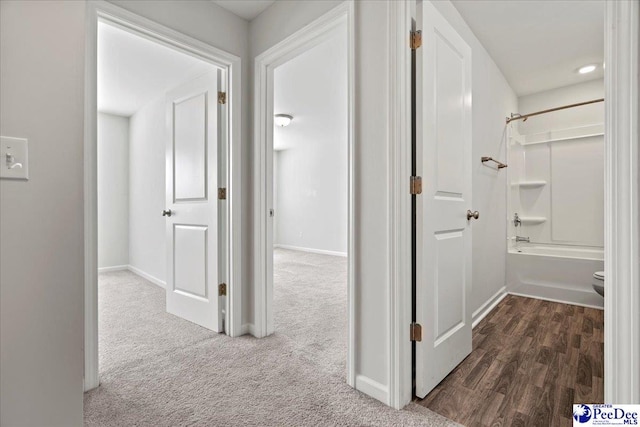 hallway with dark colored carpet