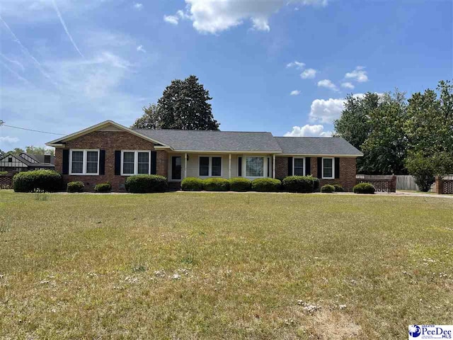 single story home featuring fence, a front lawn, and brick siding
