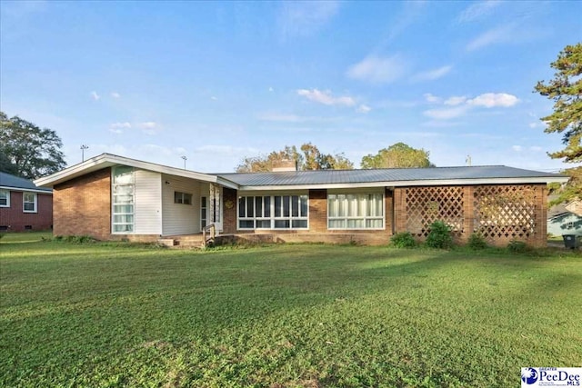 rear view of property featuring a lawn