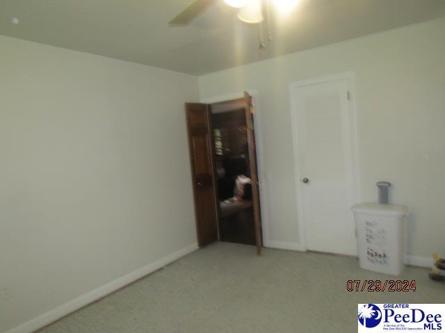 carpeted empty room featuring ceiling fan