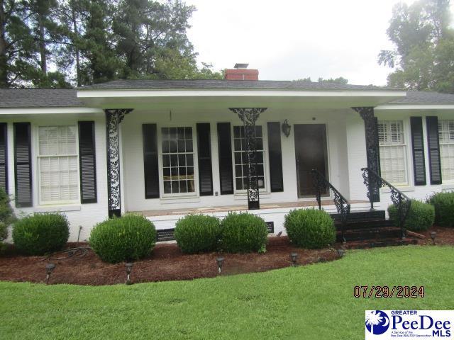 view of front of property featuring a porch and a front lawn