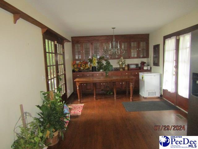 dining area featuring an inviting chandelier, dark hardwood / wood-style floors, and french doors