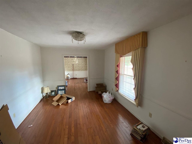 spare room featuring wood-type flooring and a textured ceiling