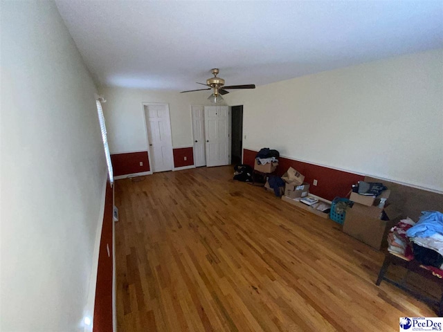 unfurnished living room featuring hardwood / wood-style flooring and ceiling fan