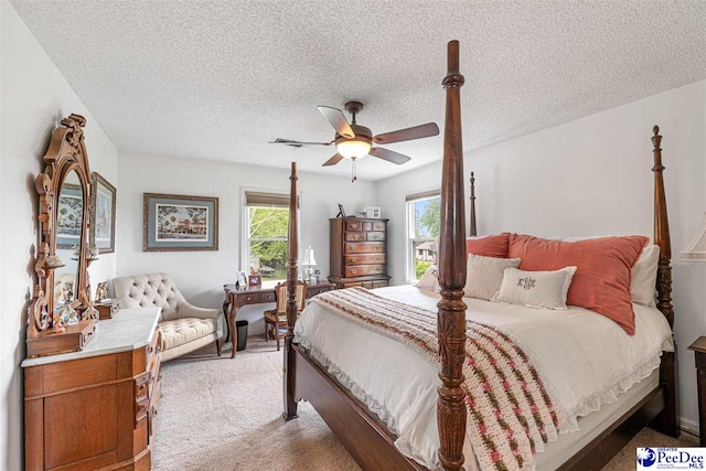 bedroom featuring light colored carpet, a ceiling fan, a textured ceiling, and visible vents