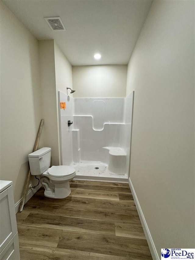 bathroom with vanity, hardwood / wood-style flooring, toilet, and a shower