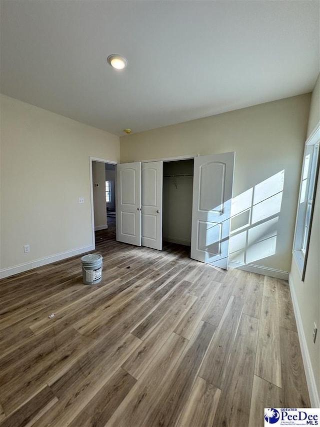 unfurnished bedroom with hardwood / wood-style floors and a closet