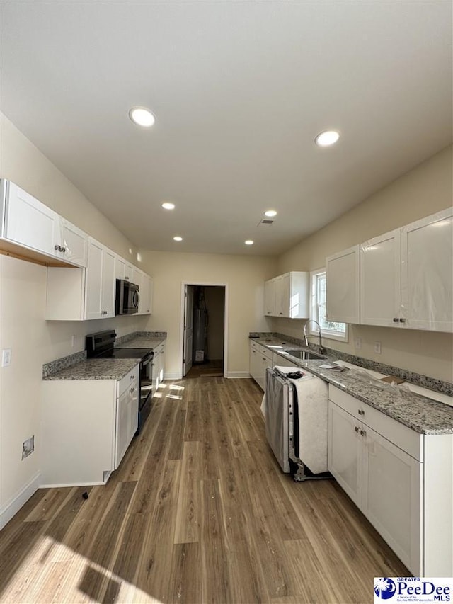 kitchen featuring sink, white cabinets, light stone counters, dark wood-type flooring, and black / electric stove