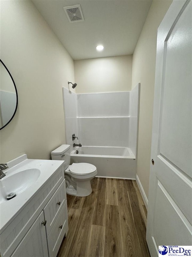 full bathroom featuring vanity, hardwood / wood-style floors, shower / washtub combination, and toilet