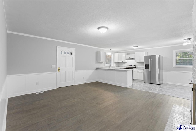 616 Sandra Ter, Florence, SC 29501 - kitchen with wainscoting, wood finished floors, a peninsula, and appliances with stainless steel finishes