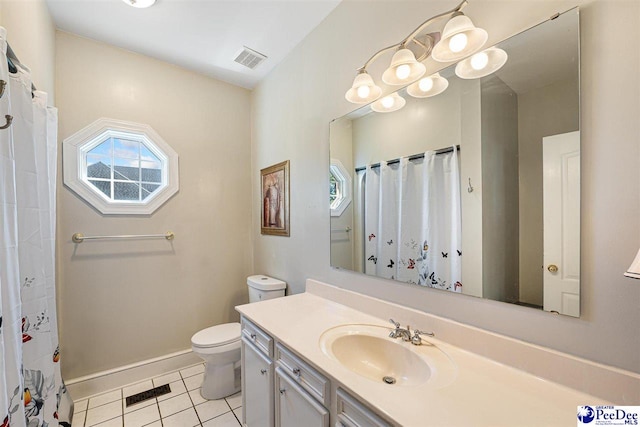 bathroom featuring vanity, a wealth of natural light, tile patterned floors, and toilet