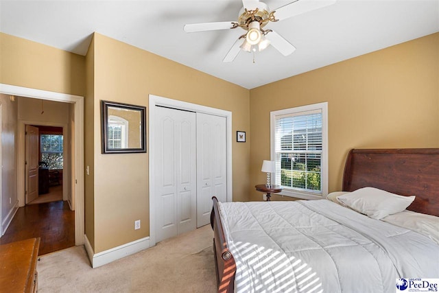 carpeted bedroom with ceiling fan and a closet