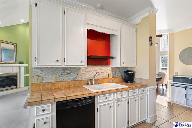 kitchen featuring sink, crown molding, black dishwasher, white cabinets, and decorative backsplash