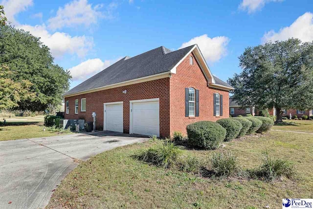 view of side of home with a garage and a lawn