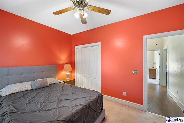 carpeted bedroom with ceiling fan and a closet