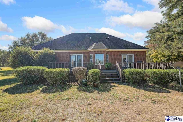 rear view of property with a deck and a lawn