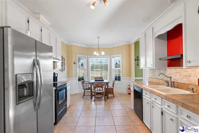 kitchen with sink, white cabinetry, hanging light fixtures, light tile patterned floors, and black appliances