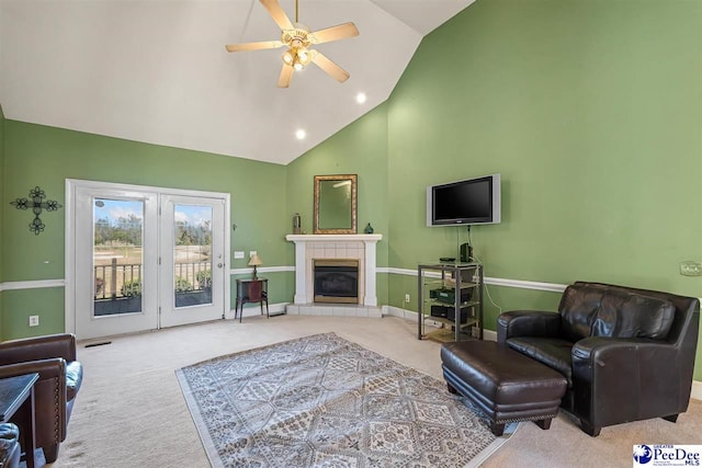 living room featuring high vaulted ceiling, light colored carpet, a tile fireplace, and ceiling fan