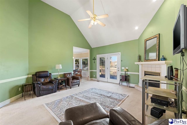 living room featuring light carpet, a fireplace, high vaulted ceiling, and ceiling fan