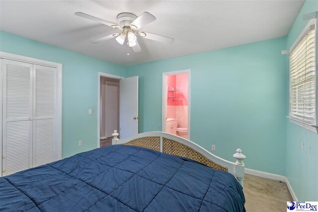 616 Forest Acres Dr, Pamplico, SC 29505 - bedroom with a closet, baseboards, carpet flooring, ensuite bath, and ceiling fan