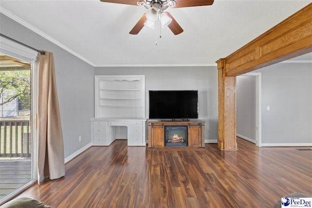 616 Forest Acres Dr, Pamplico, SC 29505 - unfurnished living room featuring dark wood-type flooring, ornamental molding, a ceiling fan, baseboards, and built in shelves
