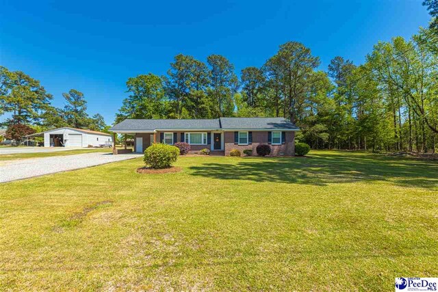 616 Forest Acres Dr, Pamplico, SC 29505 - view of front of house with a garage, a front yard, gravel driveway, and an attached carport