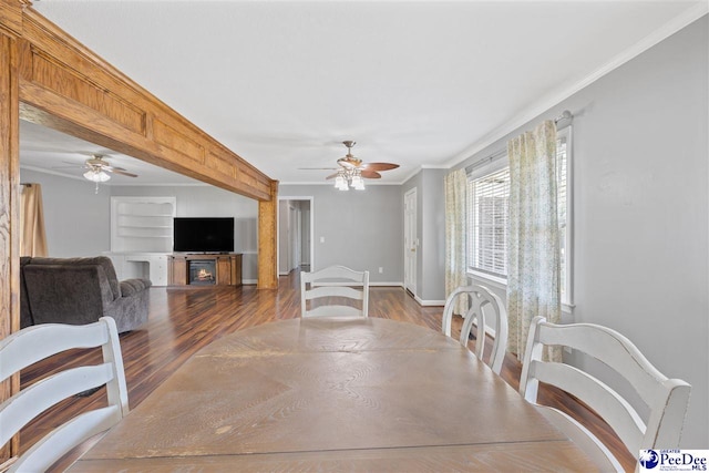 616 Forest Acres Dr, Pamplico, SC 29505 - dining space with a glass covered fireplace, dark wood-style floors, crown molding, and ceiling fan
