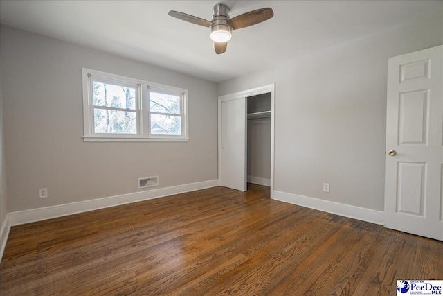 unfurnished bedroom featuring ceiling fan, dark hardwood / wood-style floors, and a closet