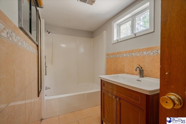 bathroom featuring tile walls, vanity, tile patterned flooring, and shower / washtub combination