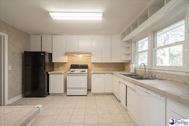 kitchen featuring sink, backsplash, white cabinets, tile counters, and white appliances