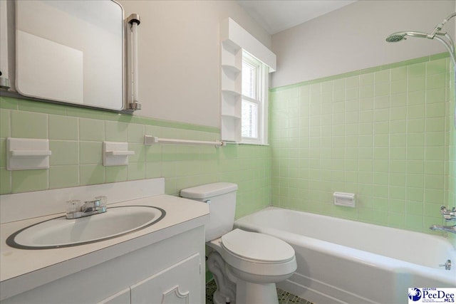 full bathroom featuring tiled shower / bath combo, vanity, tile walls, and toilet